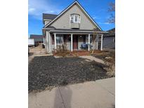 Two-story house with front porch and landscaping at 305 Strong St, Brighton, CO 80601