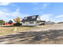 Ranch-style home with attached carport, large yard, and rural setting at 54686 E Bobcat Ln, Strasburg, CO 80136