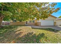 Ranch style home with attached garage and mature landscaping at 1340 Daphne St, Broomfield, CO 80020