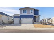 Two-story house with blue and gray siding, two-car garage, and landscaped yard at 109 Racer St, Bennett, CO 80102