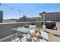 Modern rooftop deck features a glass table, chairs, and an outdoor heater at 2922 W 26Th Ave # 1, Denver, CO 80211