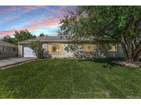 House exterior at dusk, featuring a yard and driveway at 9927 E 7Th Ave, Aurora, CO 80010