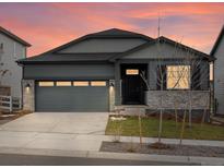 Ranch style home with gray siding, stone accents, and a two-car garage at 24088 E Atlantic Pl, Aurora, CO 80018