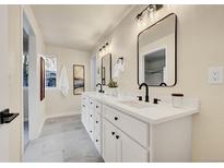 Bright bathroom boasts double vanity, modern fixtures and an elegant design at 8941 W Jewell Pl, Lakewood, CO 80227