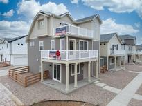 Two-story townhome with balcony, neutral siding, and a wood fence at 13448 E 103Rd Pl, Commerce City, CO 80022