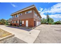 Two-story building with brick and siding exterior, attached garage, and ample parking at 9947 Croke Dr, Denver, CO 80260