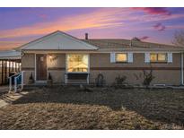Ranch style home with a well-maintained lawn and charming front porch at 7887 Quivas Way, Denver, CO 80221