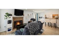 Cozy living room features a fireplace, comfortable seating, and hardwood floors at 13 Nome Way # A, Aurora, CO 80012