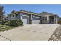 Ranch style home with three-car garage and landscaped front yard at 5219 Royal Pine St, Brighton, CO 80601