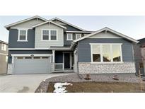 Two-story house with gray siding, stone accents, and a three-car garage at 1040 Sunrise Dr, Erie, CO 80516