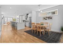 Bright, open kitchen with modern appliances, island seating, and dining area at 3822 Wyandot St, Denver, CO 80211