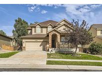 Two-story house with beige siding, brick accents, and attached garage at 10288 Salida St, Commerce City, CO 80022