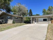 Ranch-style home with a large driveway and mature trees at 2696 S Jersey St, Denver, CO 80222