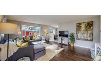 Bright and airy living room with hardwood floors and comfy sectional sofa at 28 W Broadmoor Dr, Littleton, CO 80120