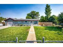 Ranch home with attached garage and landscaped yard at 1716 Main St, Strasburg, CO 80136