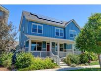 Two-story blue house with solar panels and a front porch at 5514 Uinta St, Denver, CO 80238