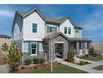 Two-story house with gray siding, teal shutters, stone accents, and a landscaped yard at 5966 N Lisbon St, Aurora, CO 80019