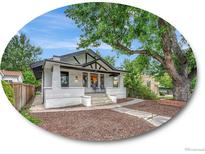 Charming white brick home with a spacious front porch and landscaped yard at 214 Colorado Blvd, Denver, CO 80206