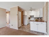 Bright eat-in kitchen with white cabinets and wood countertops at 690 S Alton Way # 1C, Denver, CO 80247