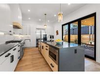 Modern kitchen with stainless steel appliances and large island at 2630 N Perry St, Denver, CO 80212