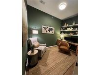 Bright home office features built-in shelves, a comfortable chair, and a large world map at 15455 Canyon Rim Dr # 307, Englewood, CO 80112