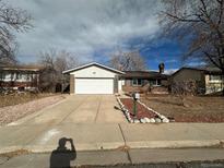 Ranch style home with attached garage and landscaped yard at 17337 E Flora Pl, Aurora, CO 80013