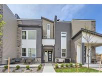 Modern two-story home with gray and beige siding, and a patio at 2584 W 69Th Pl, Denver, CO 80221