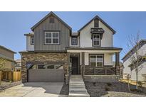 Two-story house with gray and white siding, stone accents, and a two-car garage at 24492 E Evans Dr, Aurora, CO 80018