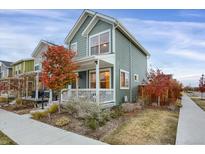 Two story craftsman style home with gray siding, front porch, and landscaping at 9349 E 57Th Pl, Denver, CO 80238