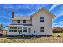 White farmhouse with a sunroom at 4550 Miller St, Wheat Ridge, CO 80033