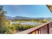 Deck overlooking a lake and mountain range at 6301 Perry Park Blvd # 13, Larkspur, CO 80118
