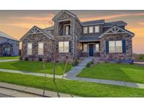 Two-story house with stone accents and a landscaped front yard at 15690 Fairway Dr, Commerce City, CO 80022