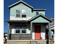 Two-story home with teal and white siding, a red door, and a gray metal railing at 21294 E 63Rd Dr, Aurora, CO 80019