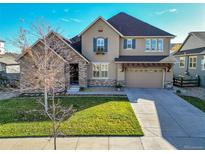 Two-story house with stone accents, a large driveway, and a landscaped lawn at 14672 Melco Ave, Parker, CO 80134