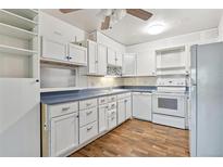 Bright kitchen features white cabinets, blue countertops, and modern appliances at 350 S Clinton St # 8C, Denver, CO 80247