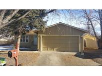 Tan single story home with a two car garage at 16753 E Ithaca Pl, Aurora, CO 80013