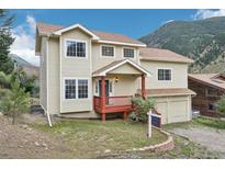 Two-story home with attached two-car garage, red deck, and mountain views at 2018 Flat Iron, Georgetown, CO 80444