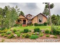 Two-story house with stone accents and landscaped yard at 7423 Cameron Dr, Larkspur, CO 80118