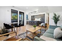 Open concept living room with modern kitchen and dining area at 1601 Park Ave # 216, Denver, CO 80218