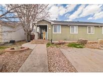 Green house exterior with a walkway, small patio, and ample parking at 2075 W Hillside Ave, Englewood, CO 80110