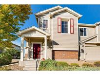 Two-story townhome with red door and brick accents, offering curb appeal at 13042 Grant E Cir # C, Thornton, CO 80241