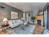 Living room with light-gray sofa, coffee table, and a fireplace at 8055 W Eastman Pl # 104, Lakewood, CO 80227