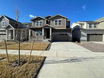 Two-story house with gray siding, attached garage, and landscaping at 12909 Range St, Firestone, CO 80504