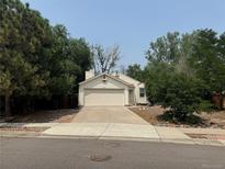 Single-story house with attached garage and driveway at 11479 E 1St Ave, Aurora, CO 80010