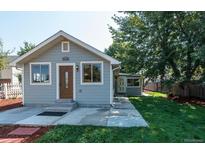 Gray house with wood front door, landscaped yard, and walkway at 4542 Sheridan Blvd, Denver, CO 80212