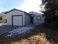 Ranch style home with attached garage and mature trees at 17443 E Temple Dr, Aurora, CO 80015