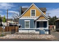 Charming two-story home with a yellow and blue exterior at 523 W 8Th Ave, Denver, CO 80204