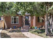 Brick home with a charming front porch and landscaped yard at 2371 Locust St, Denver, CO 80207
