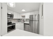 Modern kitchen with stainless steel appliances and white cabinetry at 17004 E Tennessee Dr # 210, Aurora, CO 80017