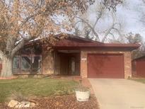 Charming single-story home with red brick exterior, attached garage, and large windows at 805 W 6Th Ave, Broomfield, CO 80020